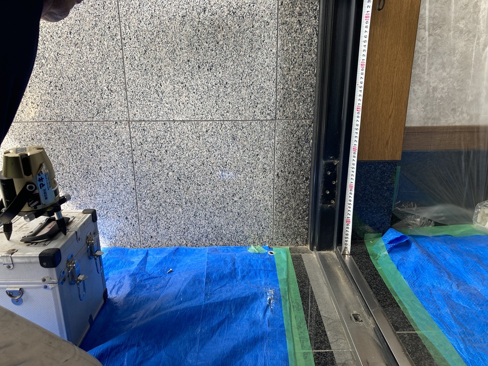 新しい玄関ドア枠を正確に取り付けるための垂直確認作業