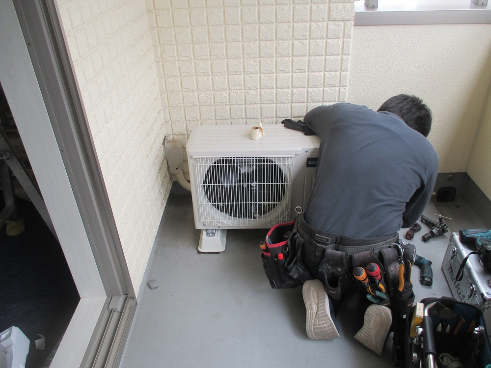 新しい室外機を設置し配管を接続する職人の作業｜静岡市施工例