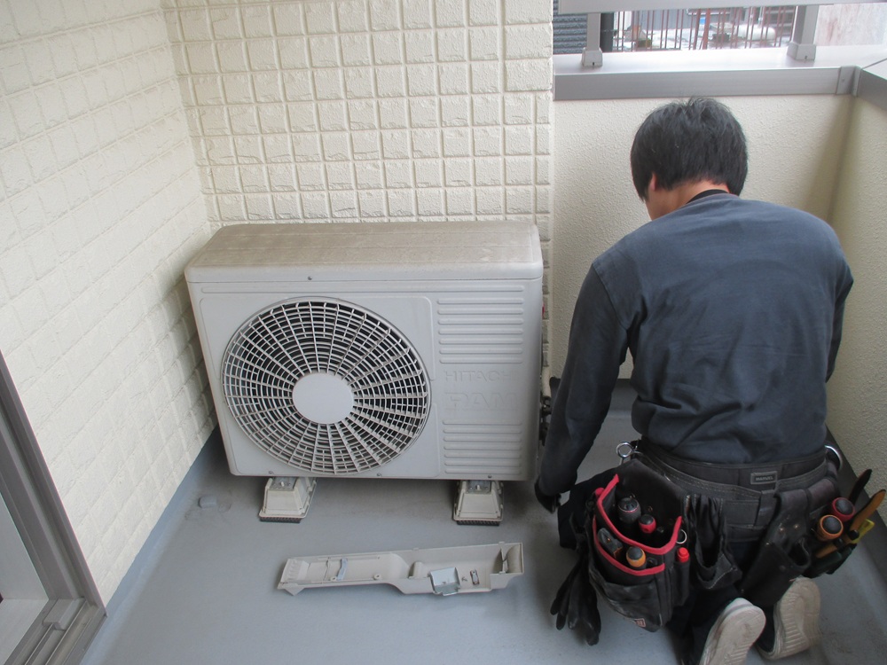 取替前の室外機と作業を準備する職人｜静岡市のエアコン交換