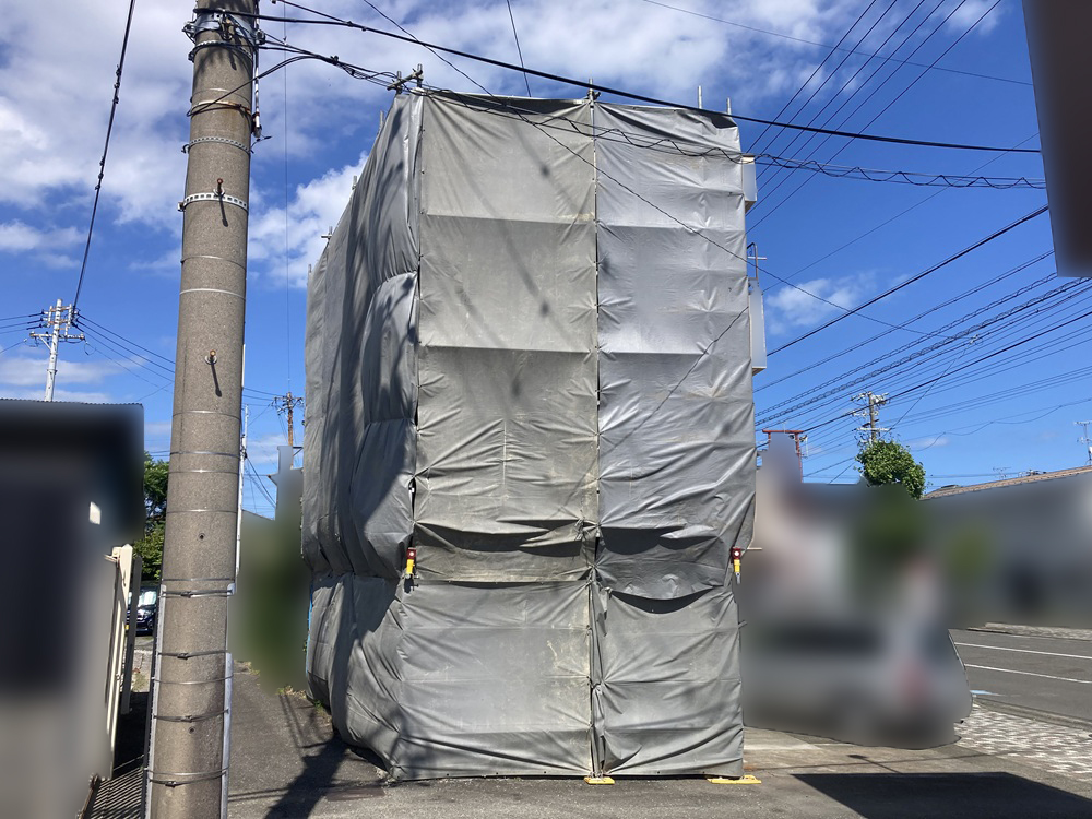 解体工事中の足場と養生シート設置による安全対策