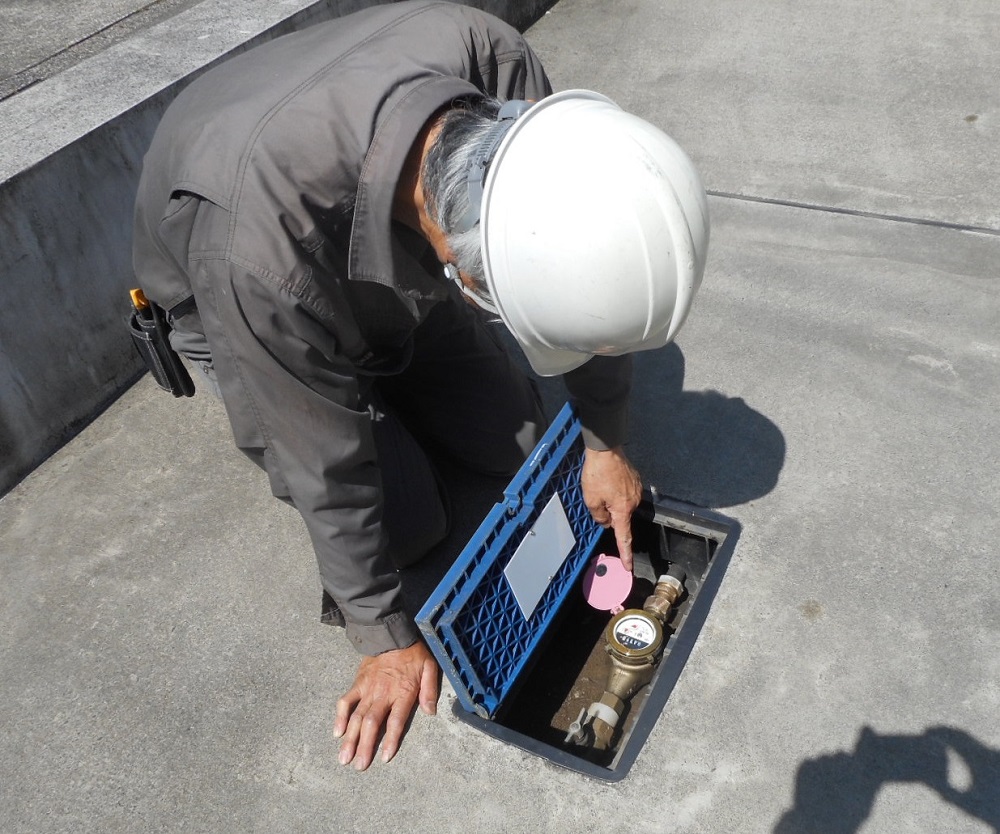 水道メーターを開けて給水管の漏水を確認する点検隊