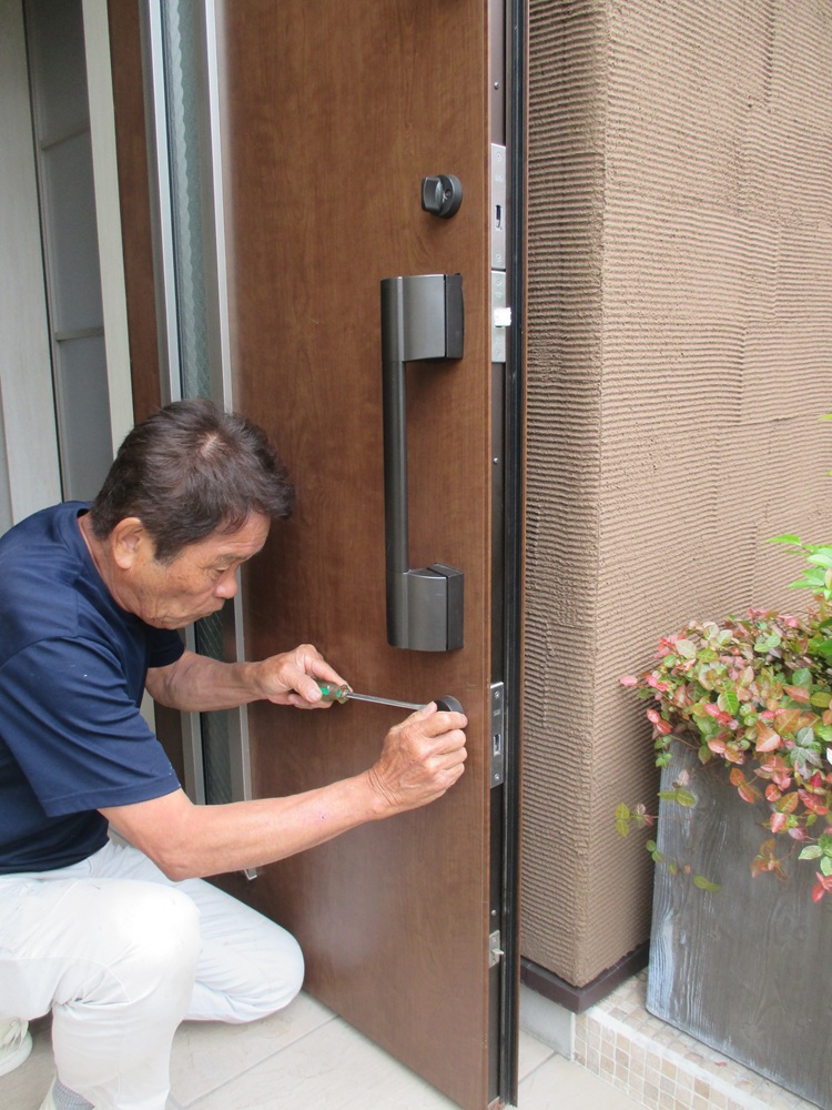 新しい玄関ドアシリンダーを取り付けている施工中の様子