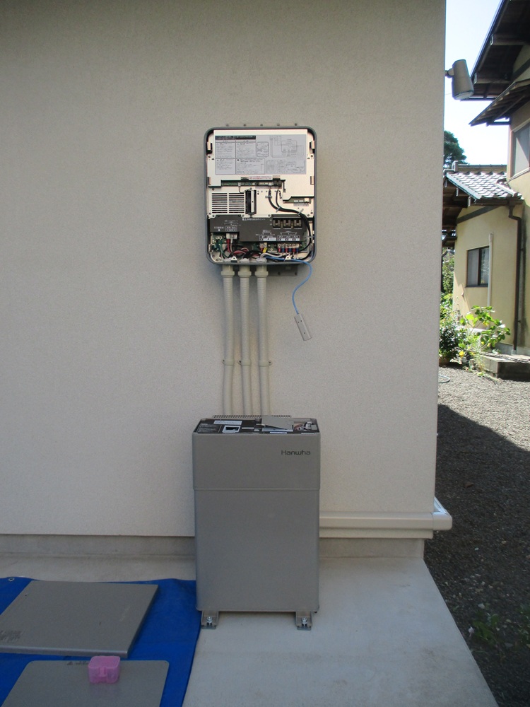 屋外で蓄電池本体を取り付けている工事中の様子。