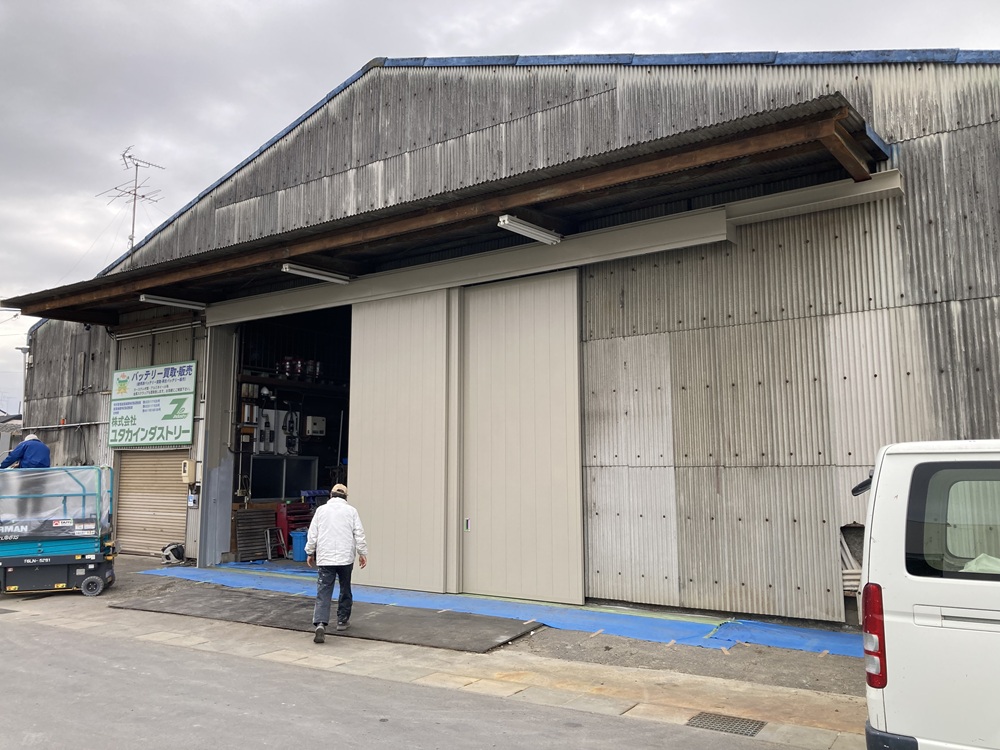 完成後の倉庫外観。明るいベージュ色の新しいハンガー戸