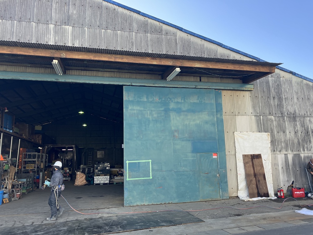 改修前の倉庫外観。緑色のハンガー戸がサビて開閉が重い状態