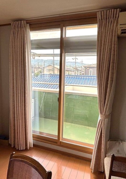 掃き出し窓に内窓と新しいカーテンを取り付けた完成後の室内