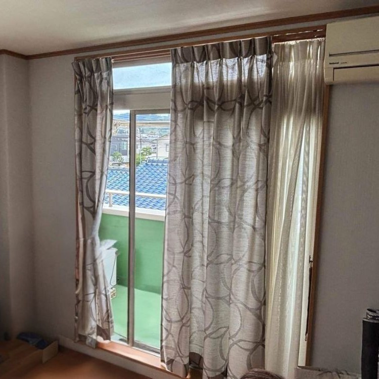 掃き出し窓の古いカーテンとレール位置の様子