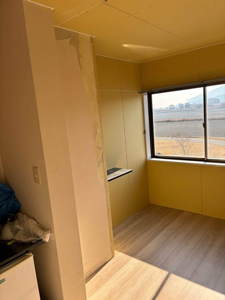 洗面台の配管を修繕し、壁と天井を復旧しているマンションの工事中の様子