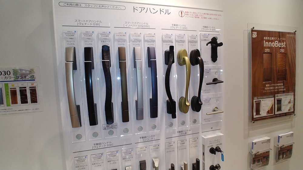 ショウルームに展示された玄関ドアのハンドル見本。形や握りやすさを比べながら選べる展示コーナー